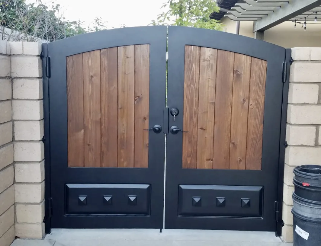 Black iron double gate with stained cedar wood panels