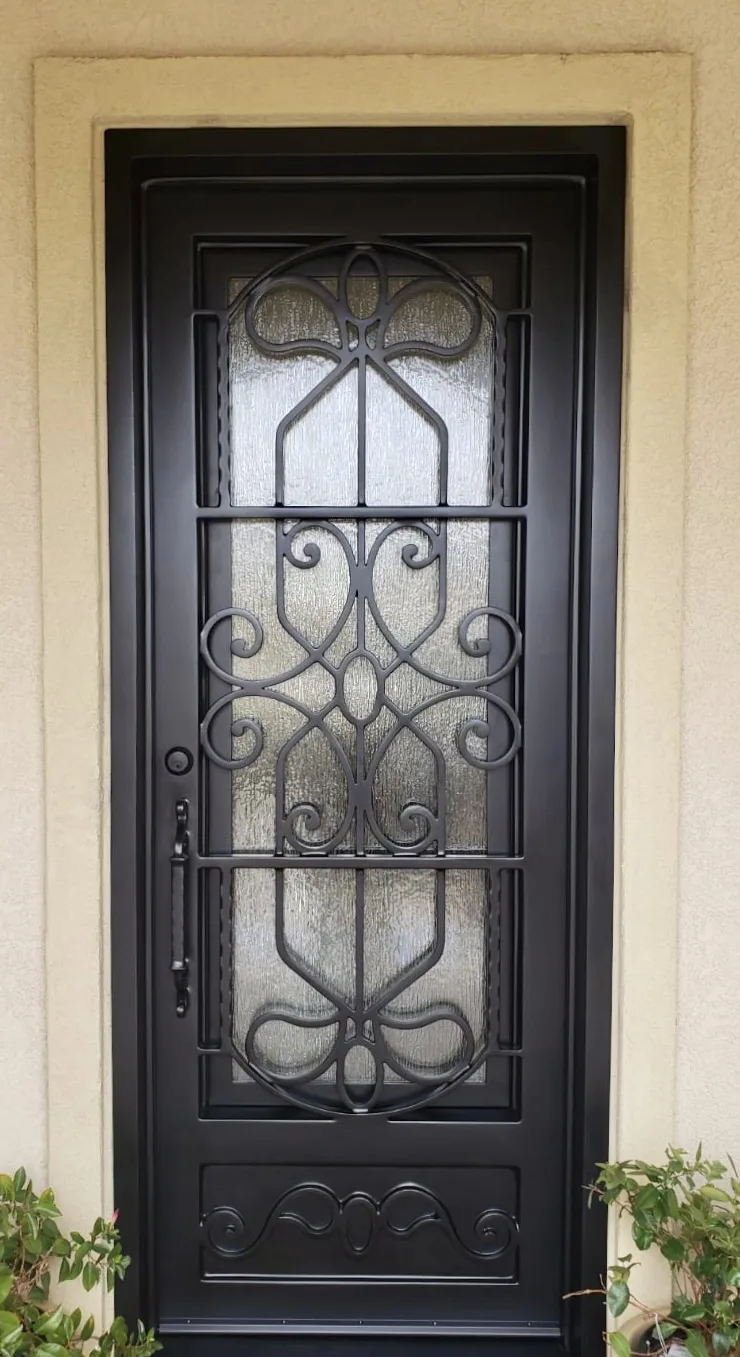 Custom black iron single entry door with scrollwork and rain glass